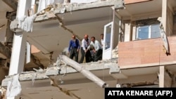 Iranians salvage a rug as they bring it down from a damaged building in the town of Sarpol-e Zahab in the western Kermanshah province near the border with Iraq, on November 14, 2017. File photo