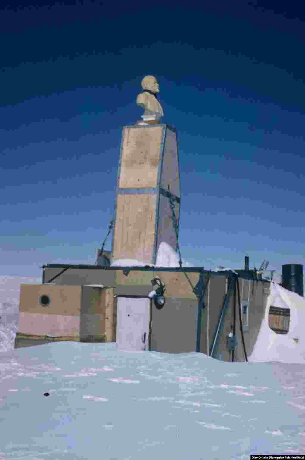 The next photos of the lonely Lenin are from the 1960s. The temporary station is already about half-buried in snow, but Lenin still looms large on top of the chimney. Olav Orheim from the Norwegian Polar Institute took this photo while participating in the second stage of the American expedition called the Queen Maud Land Traverse (1964-1967).