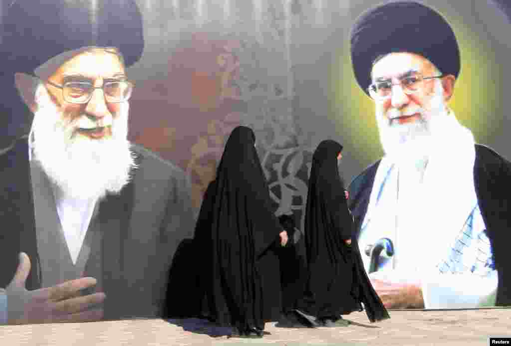 دو زن عراقی د رکنار گذر از تصاویر آیت الله علی خامنه ای، رهبر جمهوری اسلامی ایران در میدان الفردوس در بغداد