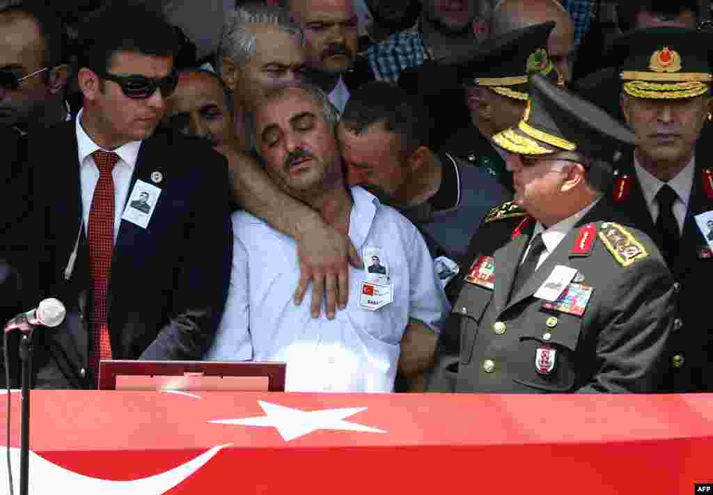 The father of late Turkish soldier Hamza Yildirim (second left) reacts in front of his son's flag-draped coffin during his funeral ceremony at Kocatepe Mosque in Ankara, Turkey, on July 31. Yildirim died when Kurdish militants attacked his convoy in the southeastern province of Sirnak. (AFP/Adem Altan)