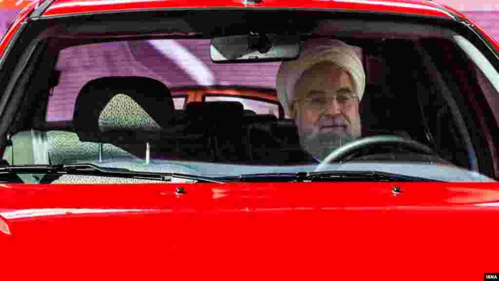 Iranian president Hassan Rohani checks out an automobile at an international carmakers&#39; conference in Tehran on March 1. (ISNA)