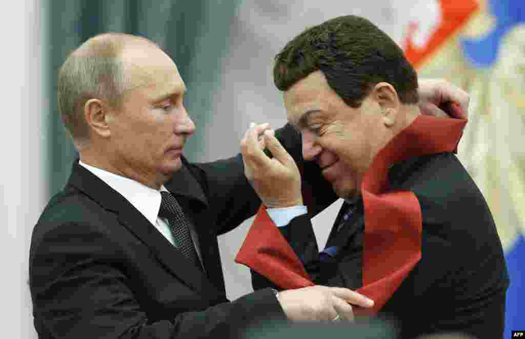 Russian President Vladimir Putin presents a medal to Kobzon during an award ceremony in the Kremlin on August 29, 2012.