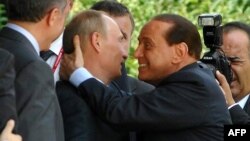 Vladimir Putin (al doilea de la stânga) se sărută cu Silvio Berlusconi (dreapta) după ceremonia semnării unui protocol la Ankara, 6 august 2009