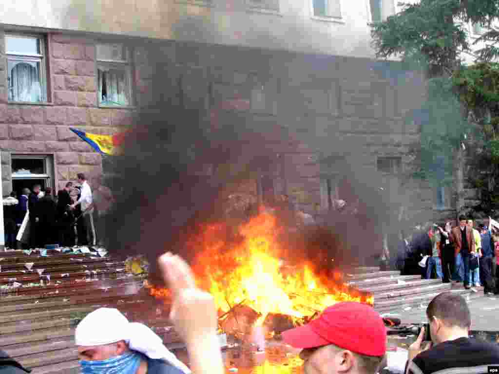 Caption: epa01690565 Young Moldovan protesters shout anti-communist slogans as a fire burns outside the parliament building in Chisinau, Moldova, 07 April 2009. Thousands of anti-communists protesters, most of them students, gathered to contest parliamentary elections results, asking for new elections. Although Moldova's ruling communist party gained enough votes to hold on to power in parliament on 05 April 2009, they lacked the number of seats to install a new president.