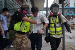 Волонтери-медики виводять потерпілого від подразливого газу поліції учасника демонстрації проти нового закону про держбезпеку в Гонконзі, 24 травня 2020 року