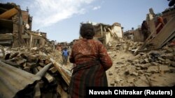Banorët duke i pastruar gërmadhat në shtëpitë e tyre të shkatërruara nga tërmeti