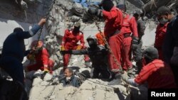 Iraqi firefighters look for bodies buried under rubble after an air strike in the city of Mosul. 