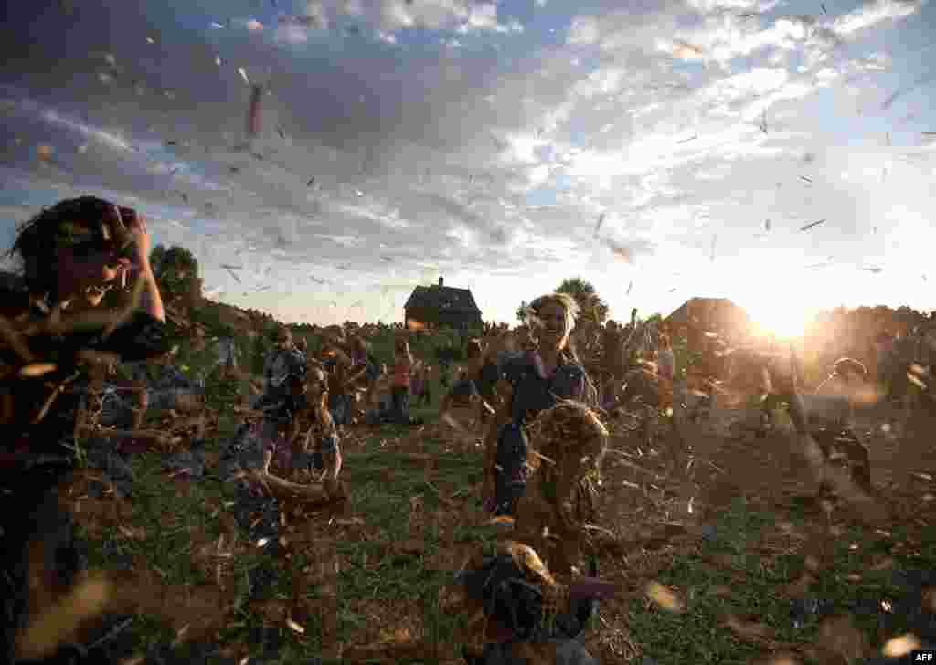 People dance and throw straw during a traditional Belarusian festival in the village of Ozerco, near Minsk, on September 7. (Uladz Hrydzin, AFP)