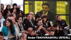 Reporters follow a Tbilisi press conference by billionaire businessman Bidzina Ivanishvili, who is seen on a big screen in the background, on November 1.