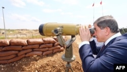 Сириядагы Сулайман Шахтын кабырына зыяратка келген түрк өкмөт башчысы Ахмед Давутоглу дүрбү менен айланага көз чаптырууда. Сирия, 10-май, 2015-жыл