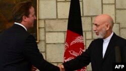 Afghan President Hamid Karzai (right) shakes hands with British Prime Minister David Cameron during a press conference at the presidential palace in Kabul on June 29.