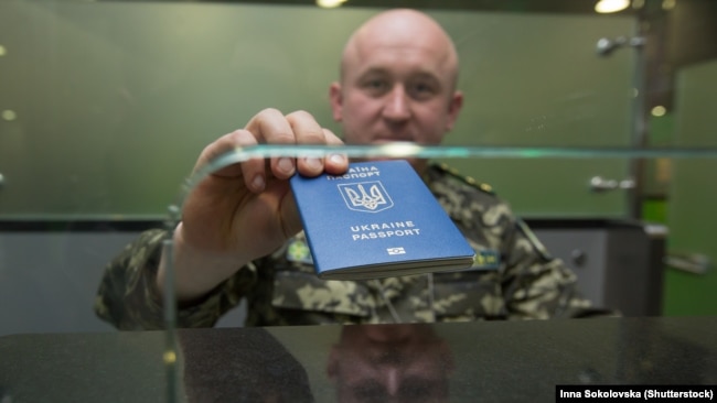 Пограничник показывает украинский загранпаспорт нового образца. Введение биометрических паспортов усложнило крымчанам поездки за рубеж. Ранее для получения загранпаспорта не требовалось личное присутствие.