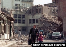 Жители Приштины идут среди руин после авиаударов войск НАТО. Косово, 7 апреля 1999 года