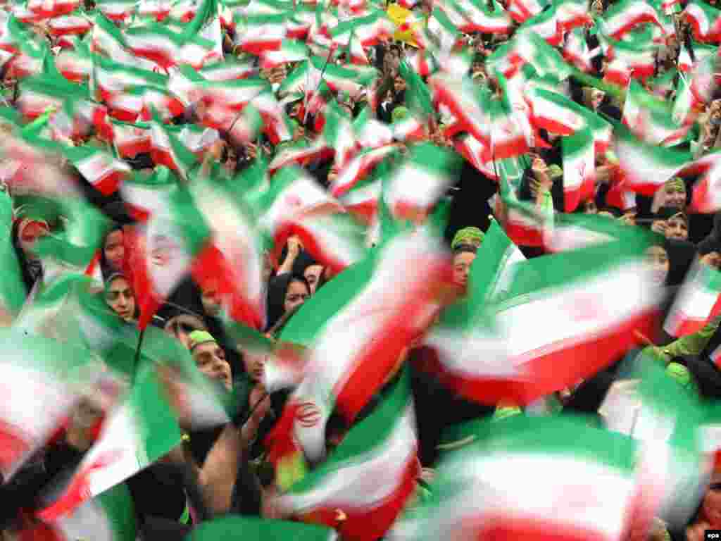 Female students wave Iranian flags on the 30th anniversary of the 1979 Islamic Revolution in Tehran on February 10.