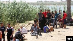 Displaced Iraqis who were forced to flee their hometowns ahead of gains made by Islamic State (IS) militants in Ramadi wait near the Bzaybiz bridge crossing the Euphrates River on their way to Baghdad, May 16, 2015