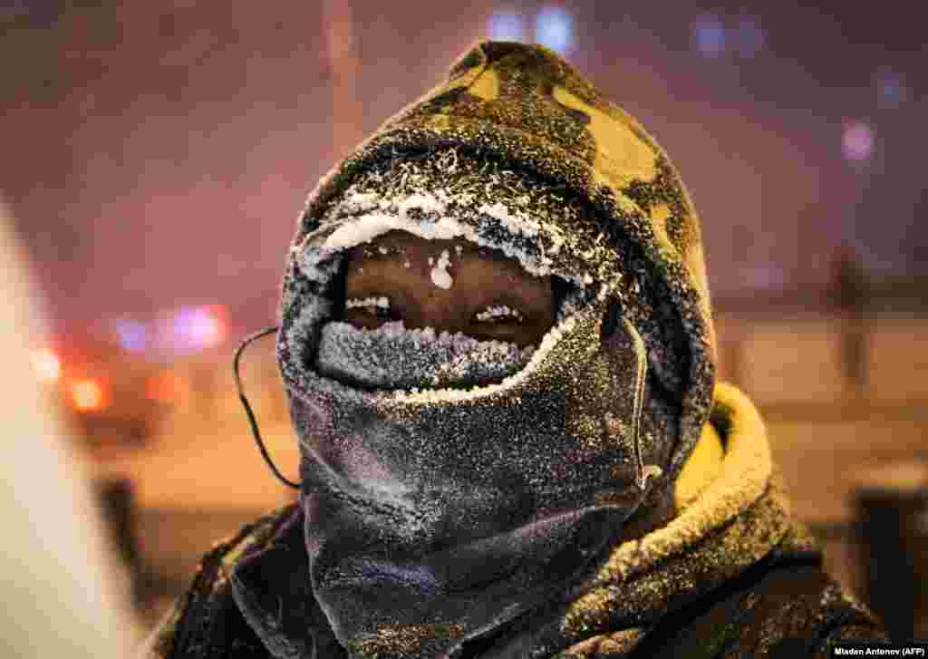 An artist poses while working on an ice sculpture on a street in the eastern Siberian city of Yakutsk. The air temperature was about minus 40 degrees Celsius. (AFP/Mladen Antonov)&nbsp;