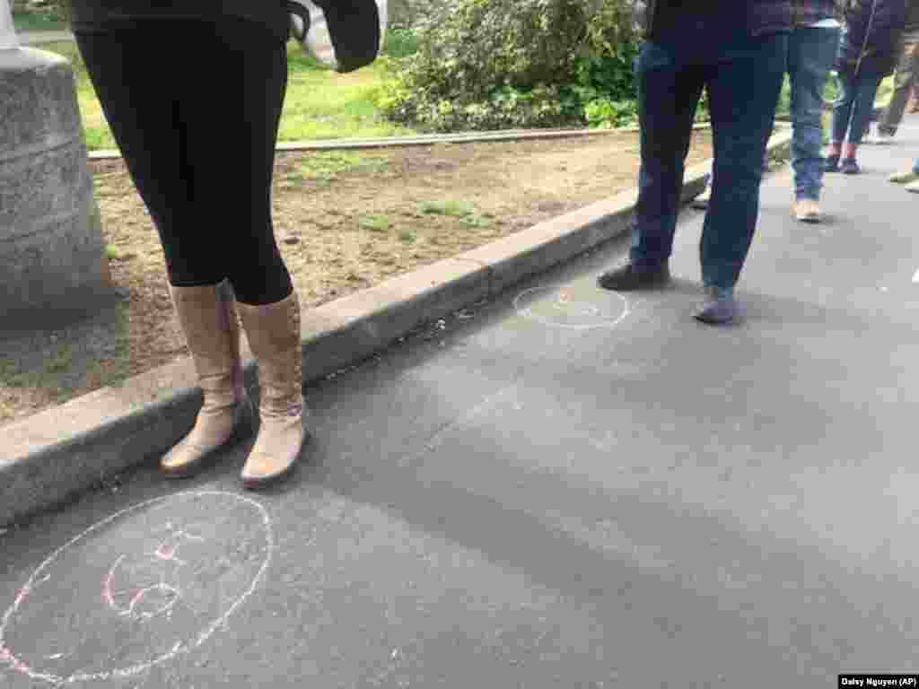 Chalk marks at a farmers market in Oakland, California, keep people at a safe distance.
