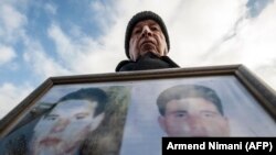 Një person mban në duar fotografinë e djalit të humbur gjatë luftës në Kosovë
