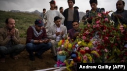 Friends and relatives of AFP photographer Shah Marai Faizi gather at his burial in Kabul on April 30 after his death in the second of two bombings that occurred in the Afghan capital.