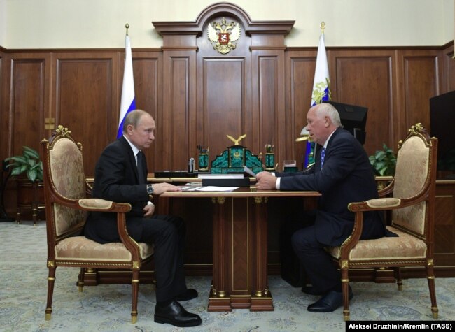 Russian President Vladimir Putin (left) meets with head of the Rostec state conglomerate, Sergei Chemezov, in Moscow in July 2019. Chemezov worked with Putin when both were KGB officers stationed in Dresden in the 1980s.