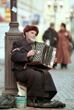 An elderly man busking in Moscow in December 1998.