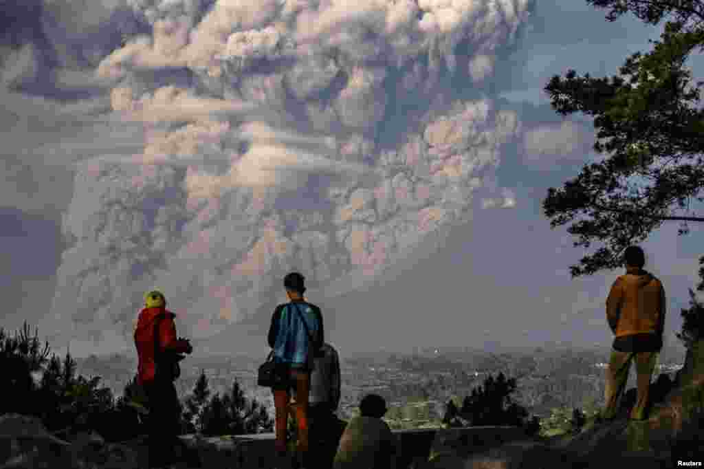 People watch as Mount Sinabung ejects ash into the air during an eruption in Karo Regency in Indonesia&#39;s North Sumatra Province on February 9. (Reuters/Antara Foto/Endro Lewa)