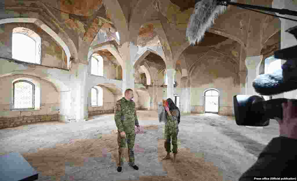 Președintele Azerbaidjanului, Ilham Aliev, și soția sa, vicepreședintele țării, Mehriban Alieva, ținând în mâini un Coran, în moscheea principală din Agdam, 22 noiembrie 2020. Fotograful Stepan Lohr spune că își face griji pentru ce se întâmplă, &bdquo;și este firesc, deoarece nu este ușor să depășești toate aceste emoții în legătură cu războiul și nenumăratele nedreptăți care se întâmplă acolo&rdquo;.