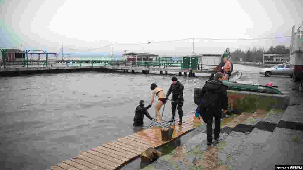 Водолаз допомагає дівчині зайти у море. Керч