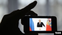 Трансляция выступления Владимира Путина на телефоне. Иллюстративное фото
