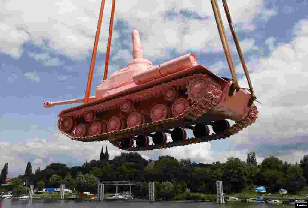 Czech Republic -- A Soviet WW II tank painted pink is loaded on a boat to be transported in Prague's city center, June 20, 2011. Original Soviet Army tank Nr. 23 was on display in Prague from the war until visual artist David Cerny painted it pink with f