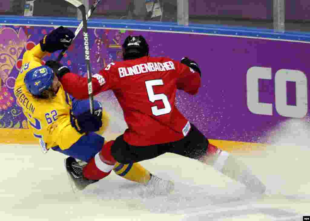 Sweden&#39;s Carl Hagelin (left) fights for the puck against Switzerland&#39;s Severin Blindenbacher during the men&#39;s preliminary-round Group C match. (EPA/Anatoly Maltsev)