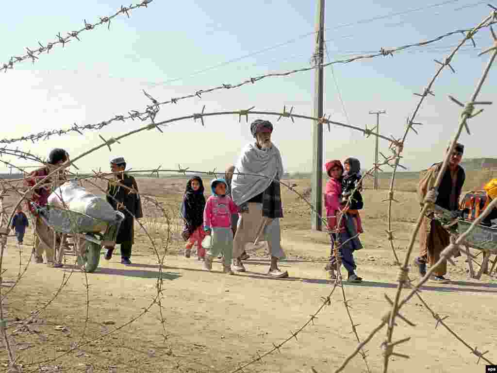 Afghanistan/Pakistan -- Afghan families cross into Afghanistan, through Pakistani border in Chaman, Pakistan, 30Jan2010 - epa02011331 Afghan families cross into Afghanistan, through Pakistani border in Chaman, Pakistan, 30 January 2010. Ethnic Pashtun tribesmen in Pakistan and Afghanistan, who live close to the Pakistan-Afghan border, are allowed to travel across the frontier without passports, but they carry special identity permits, according to an arrangement between the two countries to help members of divided tribes visit each other. EPA/MATIULLAH ACHAKZAI POTW05