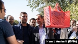 Former Iranian vice president and Ahmadinejad ally Hamidreza Baghaei showing a basket full of documents he carries to court on October 22, 2017.