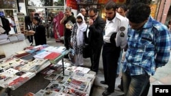 Көшеде газеттерге үңілген жұрт. Иран.