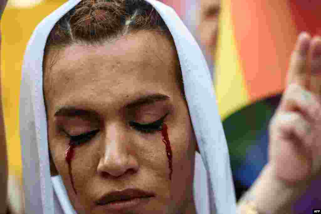 A member of Turkey's LGBT community with makeup on her face attends a rally in Istanbul to protest the murder of 22-year-old transgender activist Hande Kader. It is the second murder to strike the Turkish LGBT community after the death, on August 4, of a Syrian refugee who was found dead with his body mutilated. (AFP/Ozan Kose)