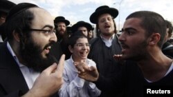 Israel -- An ultra-Orthodox Jewish man (L) argues with a secular man during a protest against the government's pledge to curb Jewish zealotry in Israel, in the town of Beit Shemesh, near Jerusalem, 26Dec2011