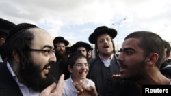 An Ultraorthodox Jewish man (left) argues with a secular man during a protest against the government's pledge to curb Jewish zealotry in Israel, in the town of Beit Shemesh, near Jerusalem, on December 26.