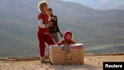 أطفال من عائلات أيزيدية في جبل سنجار قرب صندوق مساعدات غذائية 