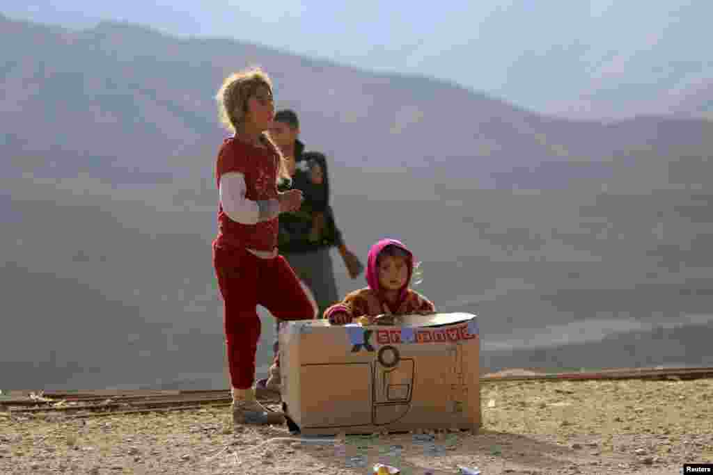 A girl from the minority Yazidi sect, many of whom have fled Islamic State militants in Iraq and Syria, sits beside a box of food aid on Mount Sinjar. (Reuters)