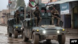 Iraqi pro-government forces patrol the eastern part of the embattled city of Mosul on December 28, during an ongoing military operation against Islamic State (IS) militants.