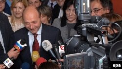 Romanian President Traian Basescu speaks to journalists while leaving his campaign headquarters in Bucharest on December 7.