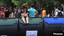 Armenia - A protester sits on a trash container forming part of a barricade on Marshal Bagramian Avenue, Yerevan, 25Jun2015.