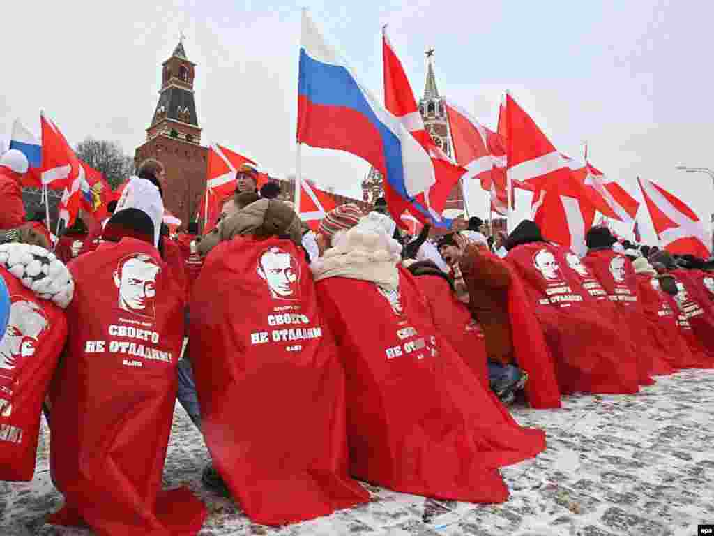 Russia -- Young people covered in red and decorated with Vladimir Putin's portraits take part in rally of pro-presidential youth movement "Nashi" celebrating the victory of United Russia in the elections, in front of Kremlin, 03Dec2007 - 3 грудня, 2007, Москва: «Наші» святкують перемогу «Єдиної Росії» Владіміра Путіна на виборах.