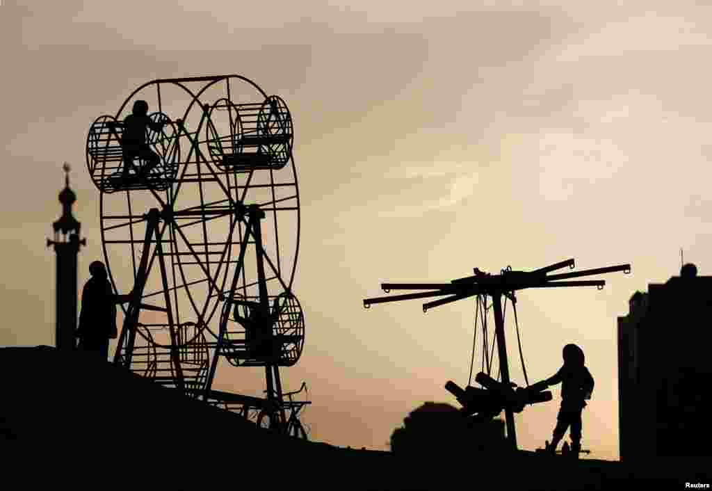 Afghan children play on a manually operated Ferris wheel in Kabul. (Reuters/Mohammad Ismail)