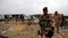 Members of Iraqi security forces are seen at a civilian airport under construction which was hit by a U.S. air strike, in the holy Shi'ite city of Kerbala, March 13, 2020