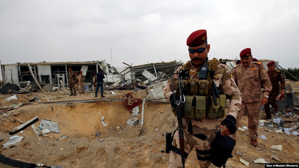 Members of Iraqi security forces are seen at a civilian airport under construction which was hit by a U.S. air strike, in the holy Shi'ite city of Kerbala, March 13, 2020