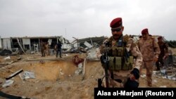 Members of Iraqi security forces are seen at a civilian airport under construction which was hit by a U.S. air strike, in the holy Shi'ite city of Kerbala, March 13, 2020