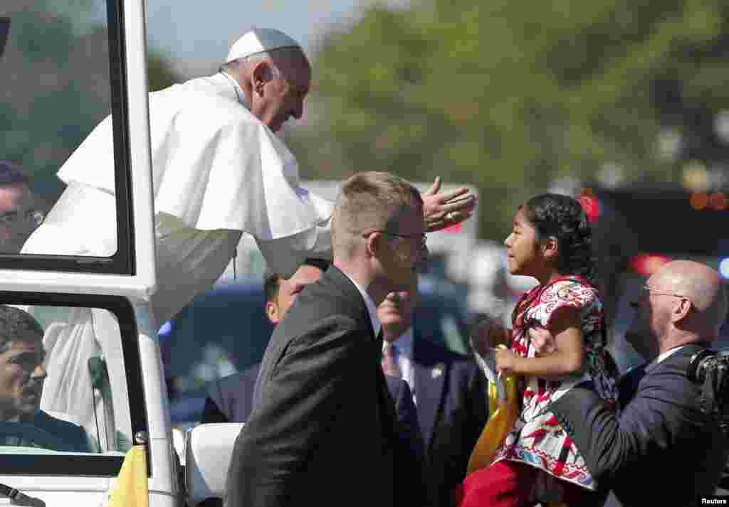 Pope Francis reaches out to 5-year-old Sofia Cruz during a papal parade in Washington, D.C. Sofia evaded security along the parade route and delivered a letter to the pope on behalf of the United States' millions of undocumented migrants. (Reuters/Alex Brandon)