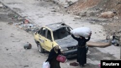 Женщины в полуразрушенном городе Алеппо в Сирии.