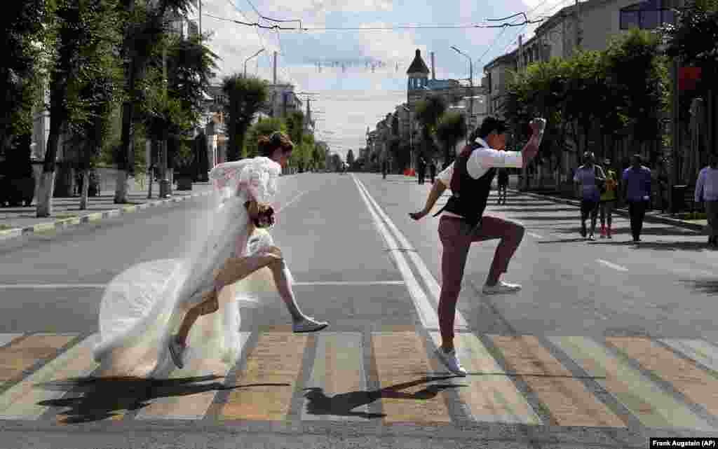 Newlyweds pose on a zebra crossing for wedding photographers during the soccer World Cup in Samara, Russia. (AP/Frank Augstein)